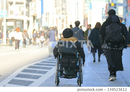 Wheelchair running through pedestrian precinct: A businessman in a wheelchair running through the pedestrian precinct in Ginza 139523612