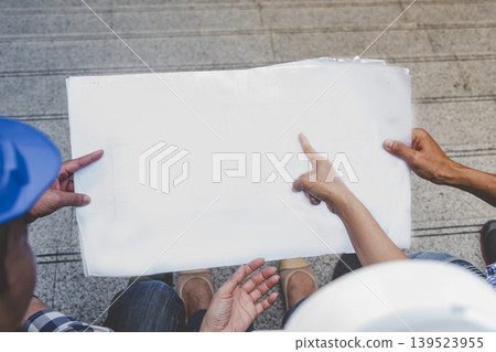 Contractor construction engineer meeting talking together on architect table at construction office site. Businessman engineer manager discuss with foreman team builder look at plan blueprint laptop Contractor construction engineer meeting talking together on architect table at construction office site. Businessman engineer manager discuss with foreman team builder look at plan blueprint laptop 139523955