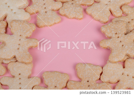 Homemade bear cookies arranged around pink backdrop, sugardusted ginger biscuits form decorative frame ideal for greeting card, invitation, or social media banner Homemade bear cookies arranged around pink backdrop, sugardusted ginger biscuits form decorative frame ideal for greeting card, invitation, or social media banner 139523981