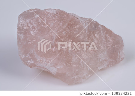 Pink quartz gemstone. Gentle rose stone on white. Pink rose quartz resting peacefully on bright background. Soft pink rose quartz displayed on clean white surface with gentle shine Pink quartz gemstone. Gentle rose stone on white. Pink rose quartz resting peacefully on bright background. Soft pink rose quartz displayed on clean white surface with gentle shine 139524221