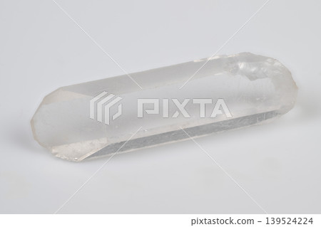 Translucent quartz prism with natural facets showcased. Photograph of pure quartz crystal with internal structures highlighted on neutral background for educational purposes Translucent quartz prism with natural facets showcased. Photograph of pure quartz crystal with internal structures highlighted on neutral background for educational purposes 139524224