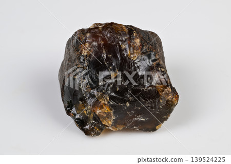 Natural amber with textured surface. Amber fragment showcasing uneven facets and rich hues. Unrefined amber piece featuring intricate surface textures and warm tones Natural amber with textured surface. Amber fragment showcasing uneven facets and rich hues. Unrefined amber piece featuring intricate surface textures and warm tones 139524225