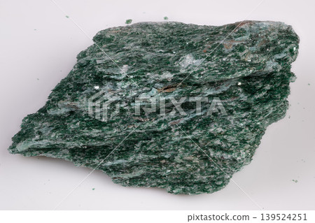 Flat view of green mica with linear foliation and reflective surfaces. Closeup of layered fuchsite muscovite showing straight foliation and shimmering green mica surfaces 139524251