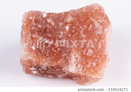 Pink halite crystal chunk on white, laboratory specimen showing coarse granular faces and sparkling salt crust, detailed macro texture for mineral research and sample photography Pink halite crystal chunk on white, laboratory specimen showing coarse granular faces and sparkling salt crust, detailed macro texture for mineral research and sample photography 139524271