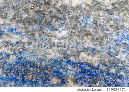 Striated bluegrey stone surface showing horizontal veins and sparkling inclusions, satellite map resemblance, cool palette suitable for geological editorial and background 139524371