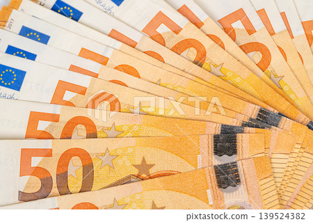 Currency notes reflect disposable income and spending habits. Semicircular arrangement of fifty euro notes illustrates economic confidence and disposable income indicators 139524382
