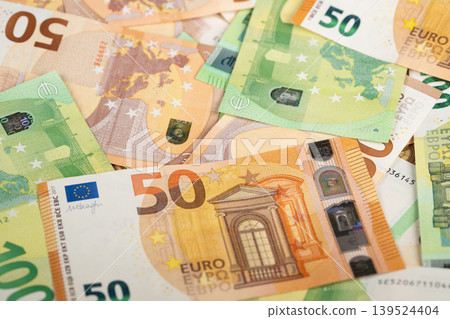 Overlapping fifty and hundred euro banknotes symbolizing investment capital and liquidity for corporate finance, startup funding or reserve assets, dynamic warmtoned composition Overlapping fifty and hundred euro banknotes symbolizing investment capital and liquidity for corporate finance, startup funding or reserve assets, dynamic warmtoned composition 139524404