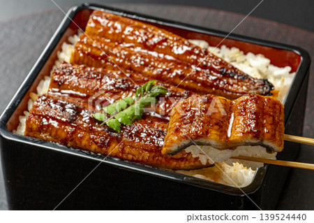 一碗看起來很美味的鰻魚飯,上面撒著山椒葉。 一碗看起來很美味的鰻魚飯,上面撒著山椒葉。 139524440
