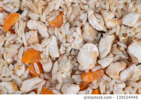 Savory chicken rice. Closeup of spiced rice with chicken and bright carrots. Rustic rice pilaf featuring succulent chicken pieces bright carrots and subtle seasoning accents 139524449