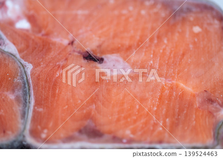 Home salmon preparation. Frozen fish thawing in kitchen. Cooking salmon steak with gentle natural lighting. Preparing healthy salmon meal for weeknight dinner scene 139524463