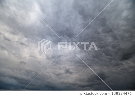 Dreary sky filled with clouds establishes solemn and gloomy environment. Somber atmosphere is intensified by thick clouds covering entire sky creating melancholic scene Dreary sky filled with clouds establishes solemn and gloomy environment. Somber atmosphere is intensified by thick clouds covering entire sky creating melancholic scene 139524475