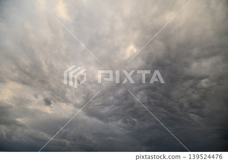 Stormy sky ahead. Dark clouds gather intensively. Foreboding clouds threaten imminent weather shift. Gloomy skies with rolling cloud formations signal upcoming stormy weather 139524476