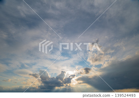 Sun and cloud scene evokes optimism. Sun rays highlight tranquil fluffy clouds atmosphere. Natural daylight breaking through clouds creates uplifting peaceful scene Sun and cloud scene evokes optimism. Sun rays highlight tranquil fluffy clouds atmosphere. Natural daylight breaking through clouds creates uplifting peaceful scene 139524493