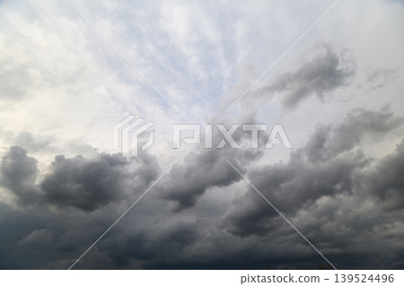 Overcast skies signal approaching storm. Brewing storm darkens vast sky above us. Thick gray clouds gather swiftly indicating impending and threatening thunderstorm 139524496