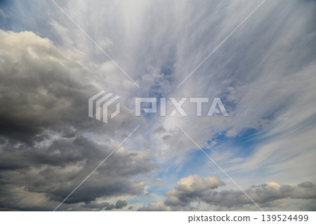 Sky abounds with turbulent storm formations. Vast sky showcases intense swirling storm clouds. Enormous sky filled with striking and chaotic storm cloud patterns 139524499