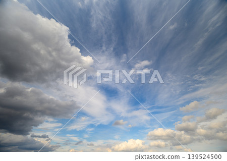 Dark dense clouds juxtapose with delicate streaks. Atmospheric scene highlights contrast between heavy storms and airy wispy clouds creating dynamic tension for storytelling Dark dense clouds juxtapose with delicate streaks. Atmospheric scene highlights contrast between heavy storms and airy wispy clouds creating dynamic tension for storytelling 139524500