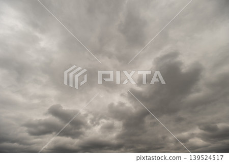 Clouds gather with swirling storms. Overcast sky filled with rotating storm systems. Dreary sky covered in swirling storm clouds indicating impending severe weather Clouds gather with swirling storms. Overcast sky filled with rotating storm systems. Dreary sky covered in swirling storm clouds indicating impending severe weather 139524517