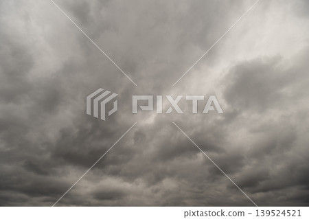 Somber horizon under heavy clouds. Dark clouds enveloping contemplative landscape. Cloud laden horizon with subdued foreground and atmosphere rich in introspective tension Somber horizon under heavy clouds. Dark clouds enveloping contemplative landscape. Cloud laden horizon with subdued foreground and atmosphere rich in introspective tension 139524521