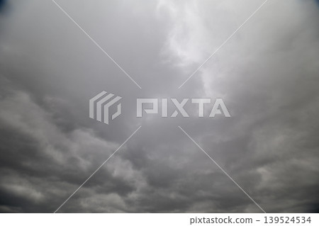 Brooding cloudy sky overcast skyline, low textured clouds layered in gray tones, dramatic shafts of diffused light, heavy mood suitable for weather backgrounds and editorial use Brooding cloudy sky overcast skyline, low textured clouds layered in gray tones, dramatic shafts of diffused light, heavy mood suitable for weather backgrounds and editorial use 139524534