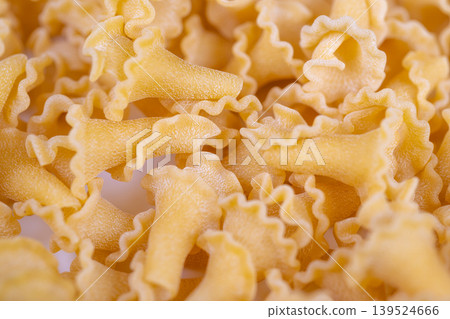 Selective focus on campanelle pasta with shallow depth, prominent ruffled edges and dusted semolina create premium hero image suitable for advertising and label hero visuals 139524666