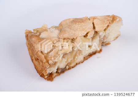 Fresh baked apple treat on plate. Warm rustic apple tart served under natural lighting. Homemade apple charlotte slice displayed on white dish with inviting atmosphere Fresh baked apple treat on plate. Warm rustic apple tart served under natural lighting. Homemade apple charlotte slice displayed on white dish with inviting atmosphere 139524677