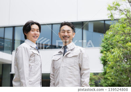 在綠樹成蔭的戶外,身著工作服的年輕工人和經驗豐富的工人正在進行房地產建築維護、基礎設施檢查和安全管理。 在綠樹成蔭的戶外,身著工作服的年輕工人和經驗豐富的工人正在進行房地產建築維護、基礎設施檢查和安全管理。 139524808