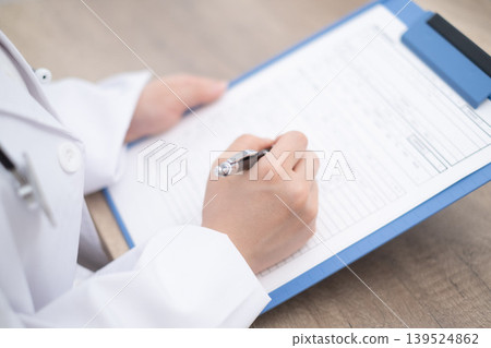 The hands of a female doctor examining a patient at a hospital. 139524862