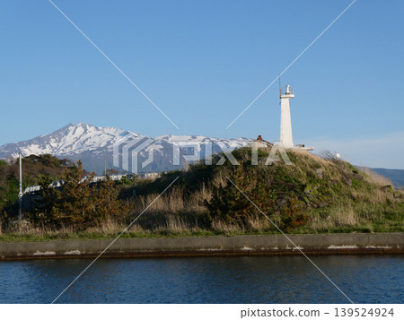 秋田縣二賀保市古浦漁港的燈塔,以及雄偉的鳥海岳景色。 秋田縣二賀保市古浦漁港的燈塔,以及雄偉的鳥海岳景色。 139524924