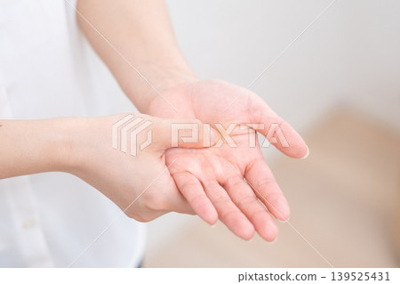 Woman with a pain in her hand 139525431