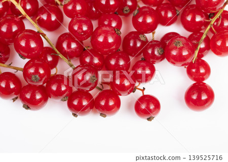 Red currant display on white background. Elegant arrangement of red currants on plain white surface with ample negative space for messaging and controlled studio lighting Red currant display on white background. Elegant arrangement of red currants on plain white surface with ample negative space for messaging and controlled studio lighting 139525716