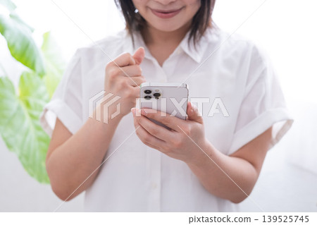 A woman who poses a gut with a smartphone 139525745