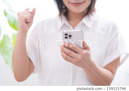A woman who poses a gut with a smartphone A woman who poses a gut with a smartphone 139525746