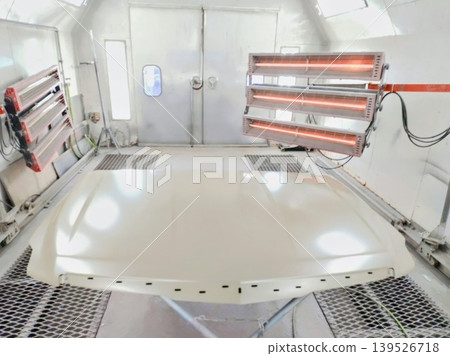 The baking process for a perfect finish. Car body parts illuminated by infrared lamps. The baking process for a perfect finish. Car body parts illuminated by infrared lamps. 139526718
