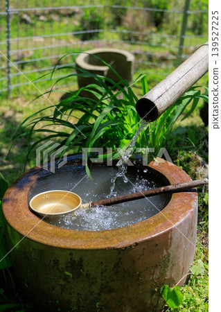 A water basin from which water flows through a bamboo pipe. A water basin from which water flows through a bamboo pipe. 139527225