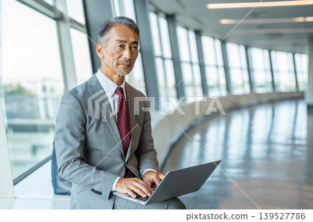 一位高級商務人士正在操作筆記型電腦 一位高級商務人士正在操作筆記型電腦 139527786