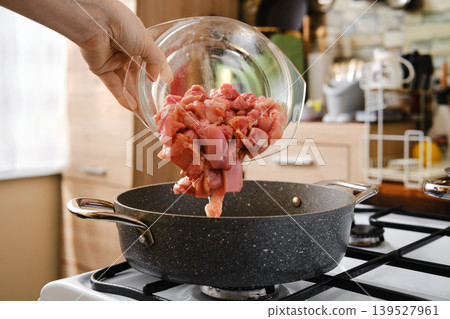 Add chopped chicken meat in frying pot Add chopped chicken meat in frying pot 139527961