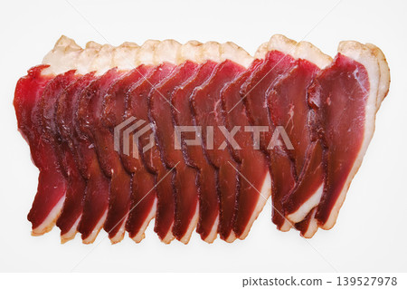 Sliced cured duck meat arranged in a row on a plain background showcasing food preparation Sliced cured duck meat arranged in a row on a plain background showcasing food preparation 139527978