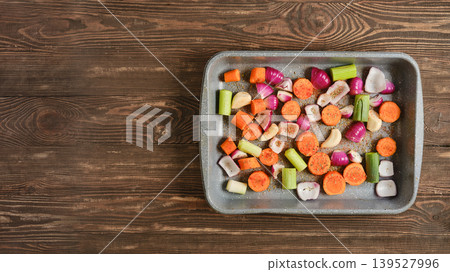Mixed vegetables on a baking tray prepared for roasting in a kitchen environment 139527996