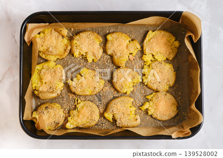 Crispy smashed potatoes on a baking sheet ready for serving at a casual dining event Crispy smashed potatoes on a baking sheet ready for serving at a casual dining event 139528002