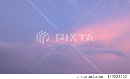 A serene twilight sky is saturated with vibrant pink, purple, lavender tones. The colors blend into soft blue on the upper left, creating a beautiful, ethereal, expansive nature background. A serene twilight sky is saturated with vibrant pink, purple, lavender tones. The colors blend into soft blue on the upper left, creating a beautiful, ethereal, expansive nature background. 139528302
