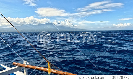 View of the vast ocean with waves, a mountainous horizon seen from an outrigger boat. Dauin, Philippines View of the vast ocean with waves, a mountainous horizon seen from an outrigger boat. Dauin, Philippines 139528782