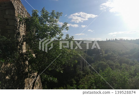 Fluffy white clouds over green landscape on a sunny day 139528874