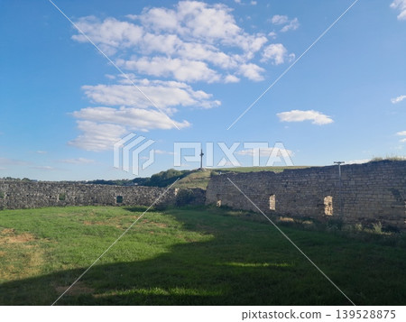 Fluffy white clouds over green landscape on a sunny day 139528875