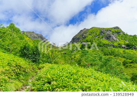 The rocky peaks of the Northern Alps and the mountain landscape shrouded in mist, as seen from the Mt. Yake climbing trail. The rocky peaks of the Northern Alps and the mountain landscape shrouded in mist, as seen from the Mt. Yake climbing trail. 139528949