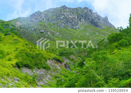 The rocky peaks of the Northern Alps and the mountain landscape shrouded in mist, as seen from the Mt. Yake climbing trail. The rocky peaks of the Northern Alps and the mountain landscape shrouded in mist, as seen from the Mt. Yake climbing trail. 139528954