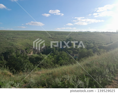 Fluffy white clouds over green landscape on a sunny day 139529025