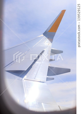 View through airplane window, passenger seat, wing View through airplane window, passenger seat, wing 139529125