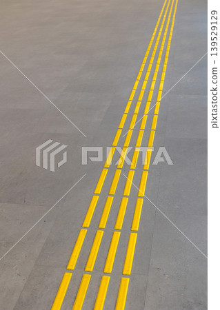 Yellow tactile paving tiles in airport terminal Yellow tactile paving tiles in airport terminal 139529129