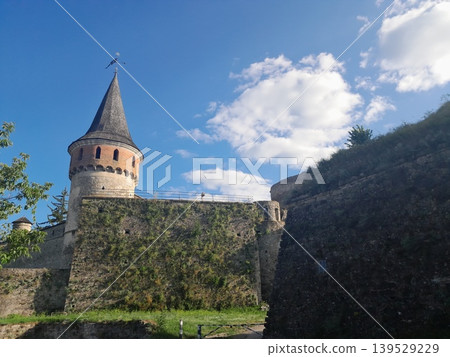 Ancient stone fortress wall under blue sky, historic architecture detail Ancient stone fortress wall under blue sky, historic architecture detail 139529229