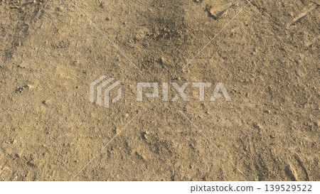 Dry brown soil features rough textures, scattered stones. This natural earth background captures agricultural land under warm sunlight. Perfect for farming, construction themes. Dry brown soil features rough textures, scattered stones. This natural earth background captures agricultural land under warm sunlight. Perfect for farming, construction themes. 139529522